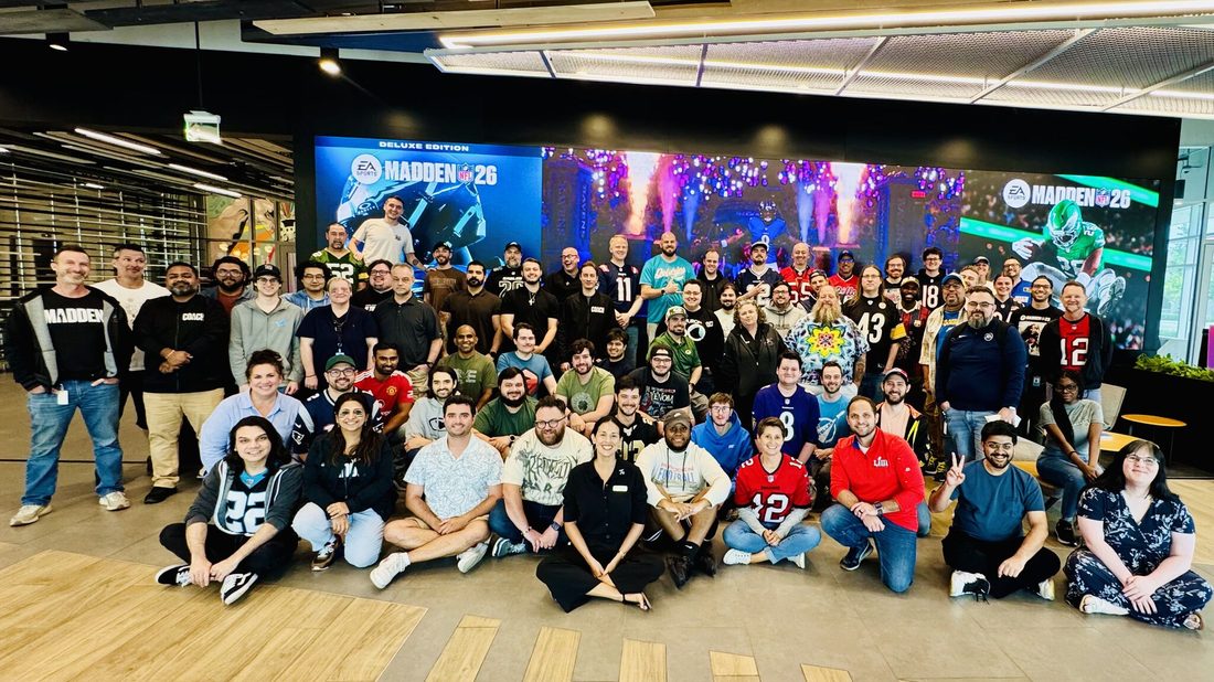 The EA Tiburon team gathered in front of Madden NFL 26 screens on launch day